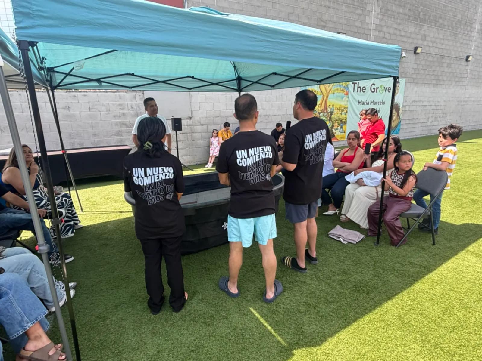 El equipo del bautizo de espaldas, con la camiseta que dice «Un nuevo comienzo»