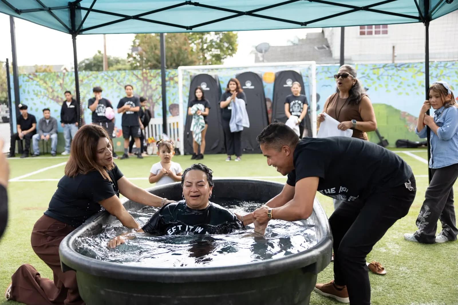 Una mujer sale del agua sonriendo mientras la iglesia mira desde el otro lado de la cancha