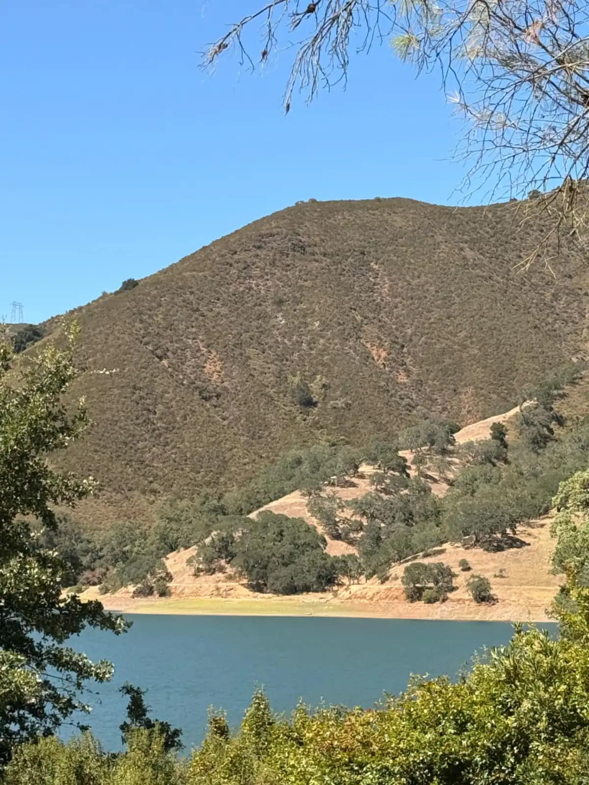 El lago visto desde el campamento, con el cerro seco levantándose al otro lado del agua
