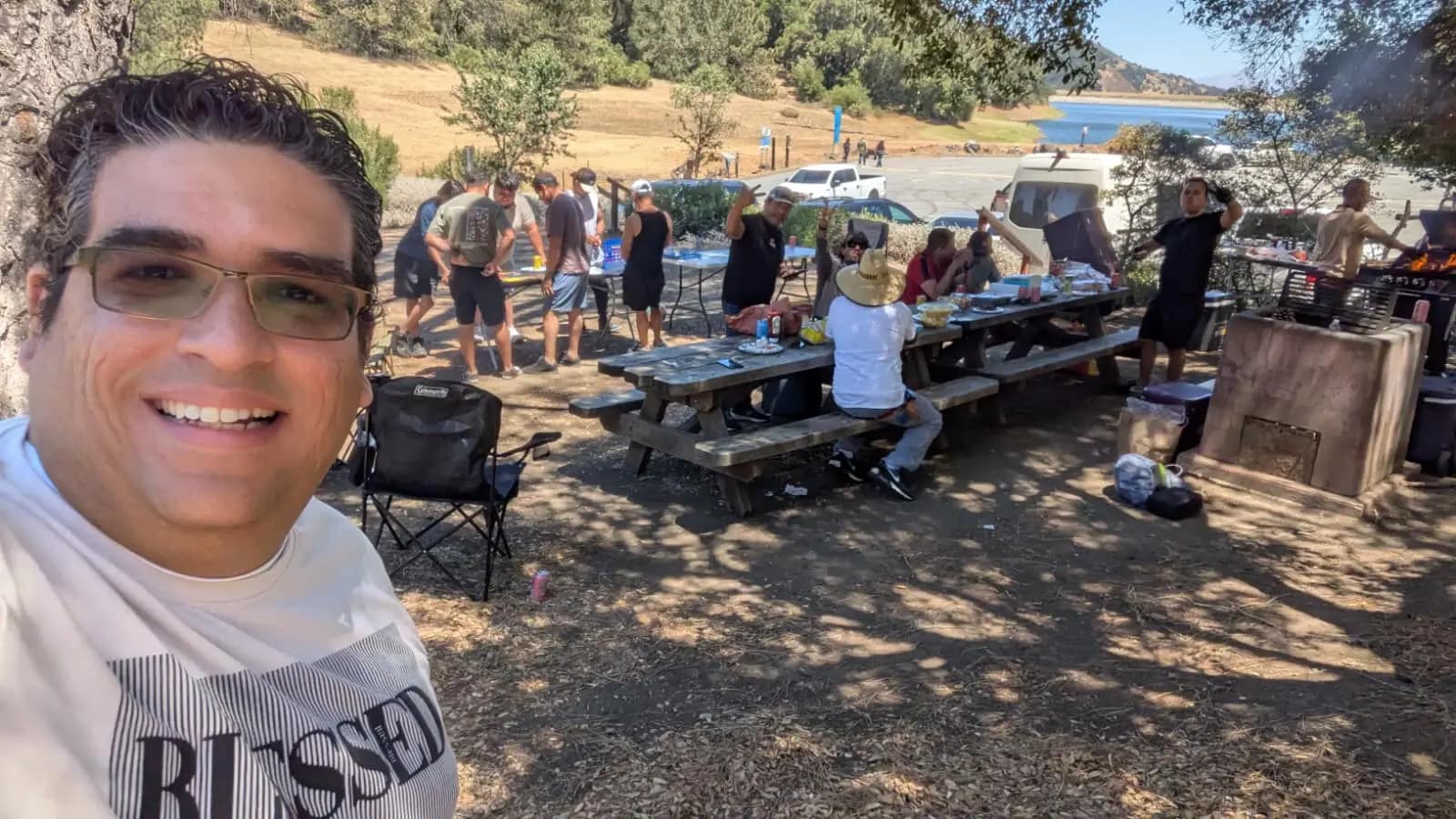Selfie de uno del grupo con el campamento y las mesas del almuerzo a su espalda