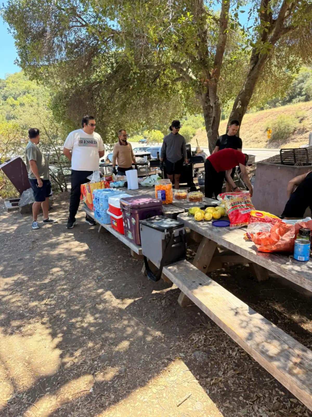 La mesa de picnic cargada de agua, limones y comida mientras el grupo la organiza