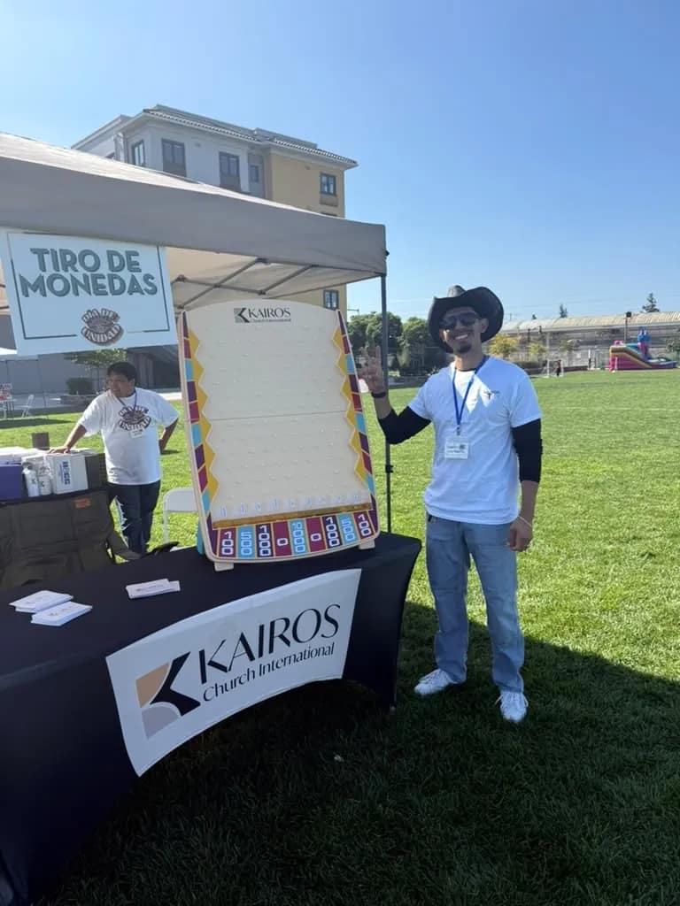 Voluntario junto al juego de tiro de monedas montado en el puesto de Kairos