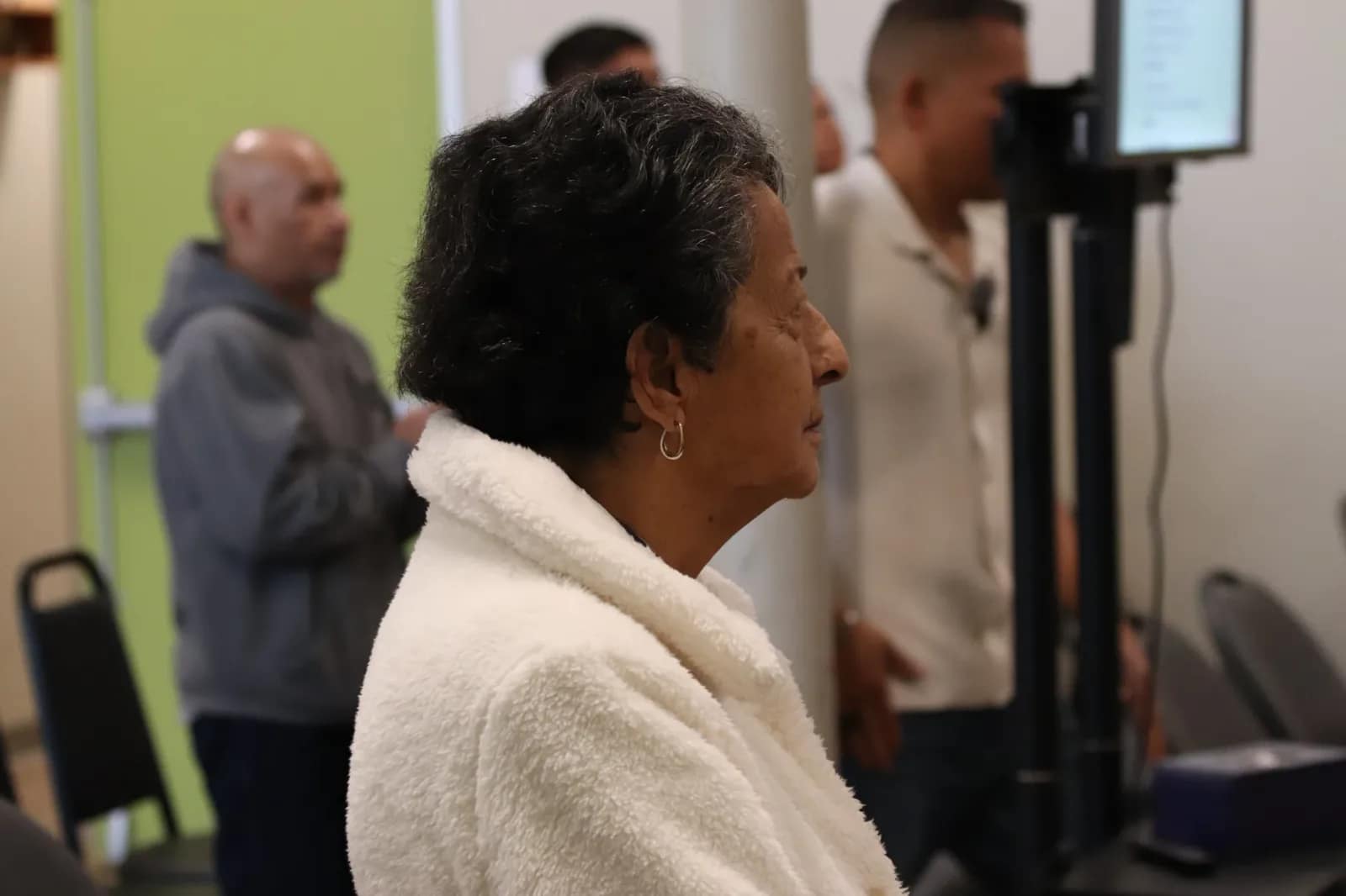 Una señora sigue la alabanza de pie desde su sitio