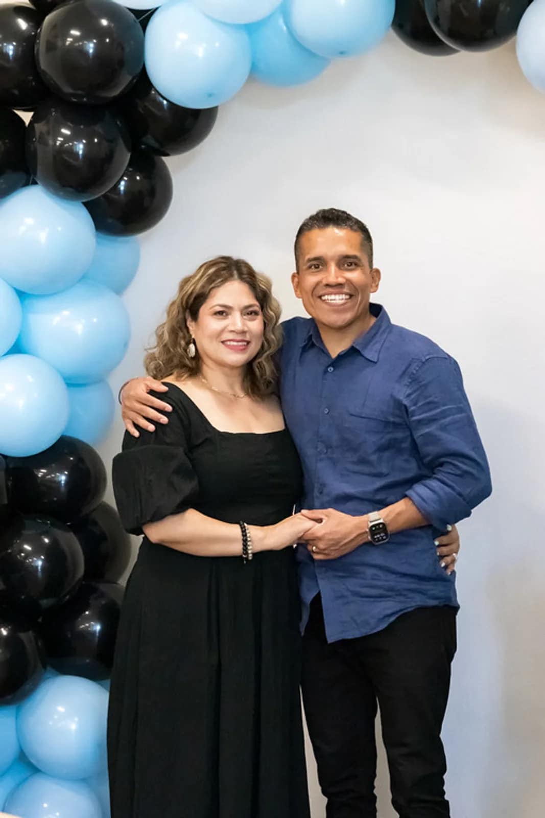 Un matrimonio de la iglesia posa delante del arco de globos al final del servicio