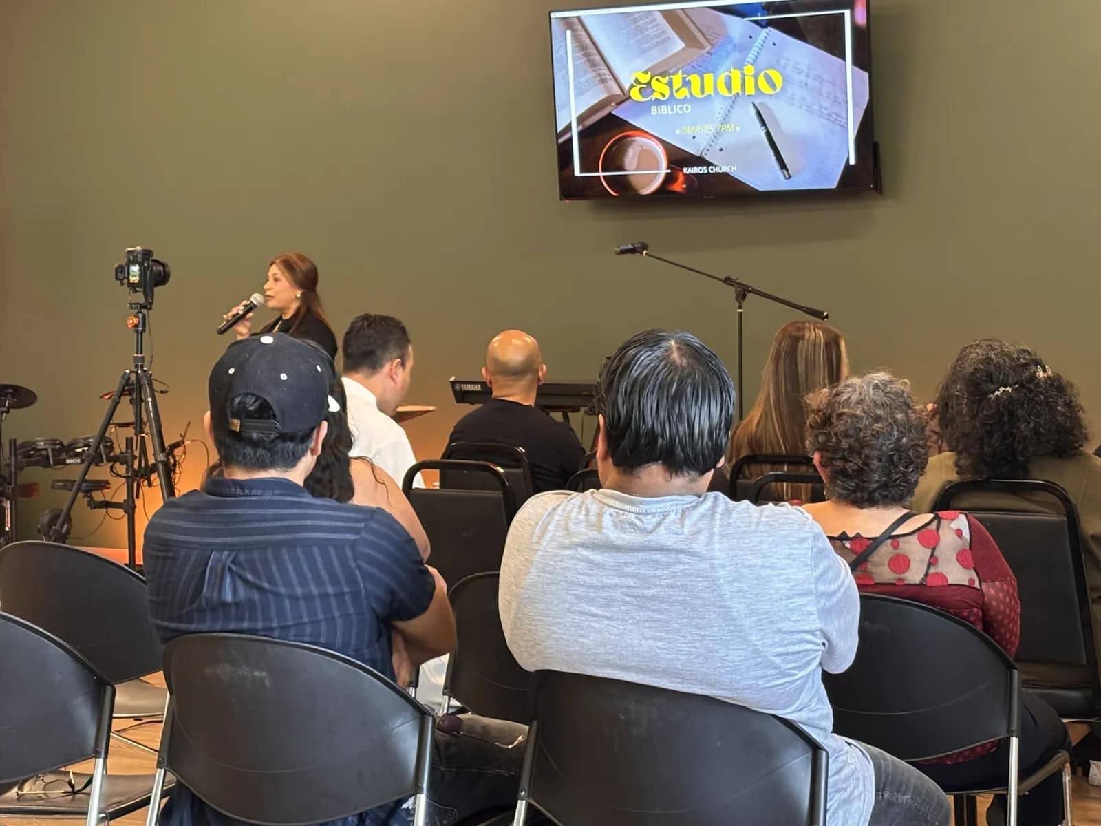 La congregación sentada durante el estudio bíblico, con la pantalla encendida al frente