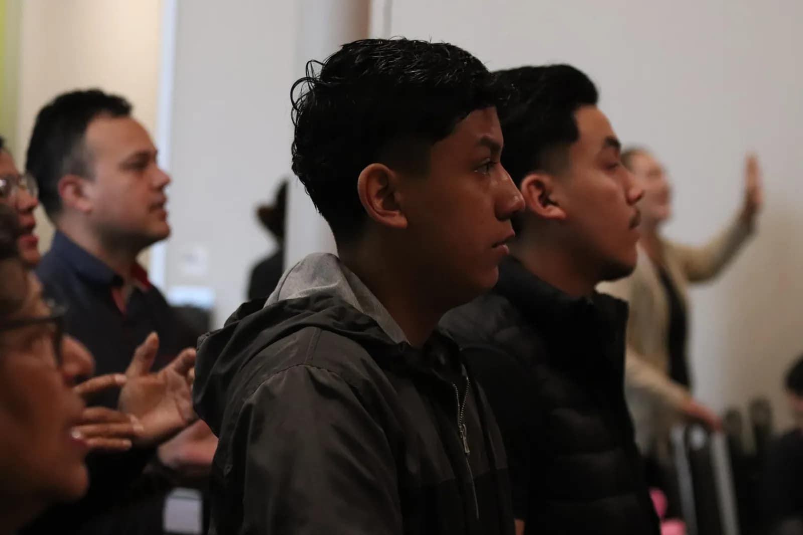 Los jóvenes cantan de pie durante la alabanza del servicio