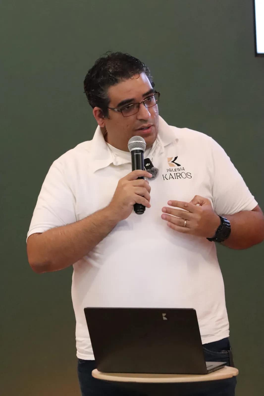 El anfitrión da la bienvenida con el micrófono y la tablet en la mano