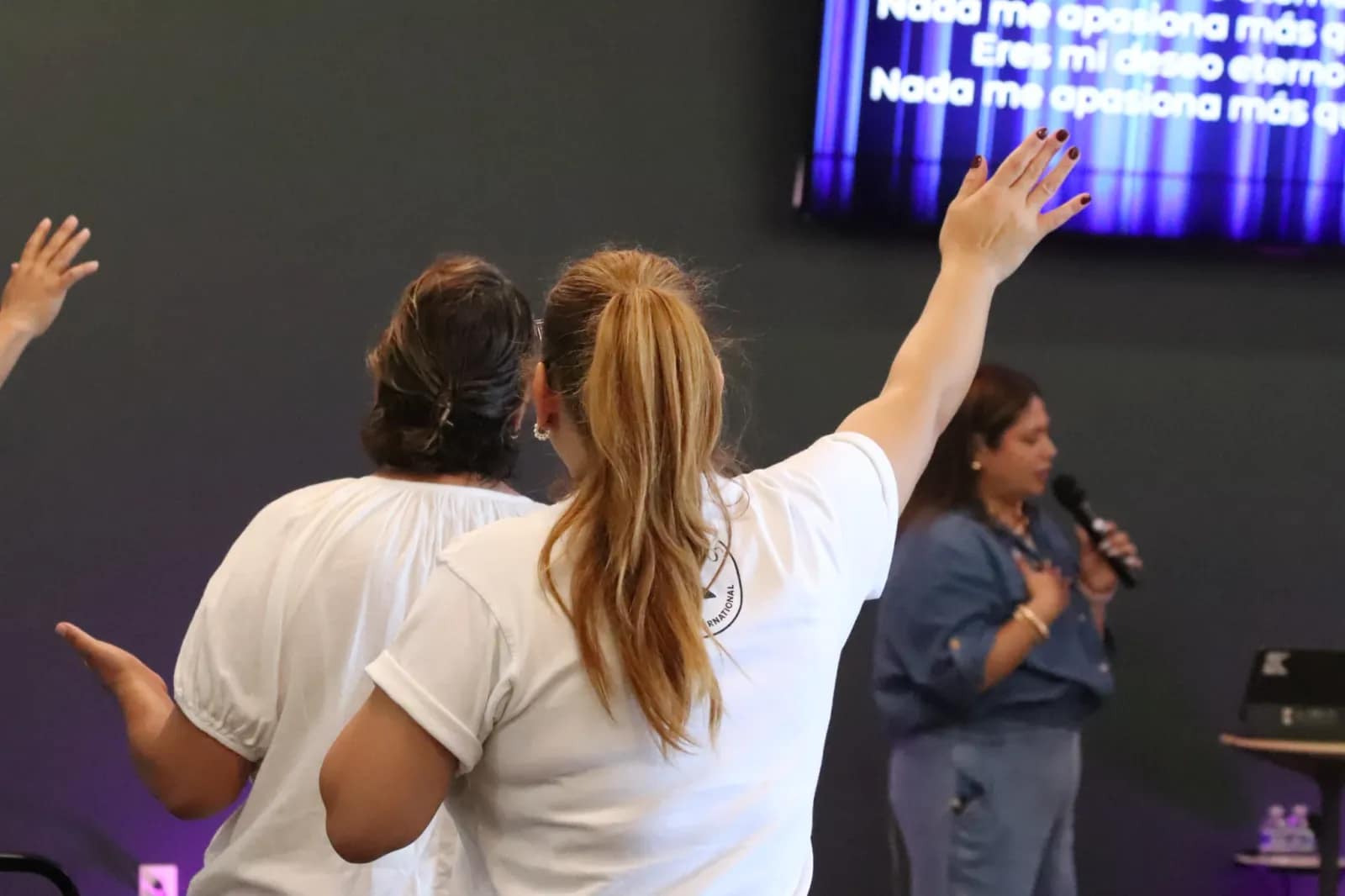 Manos levantadas al frente mientras la congregación adora