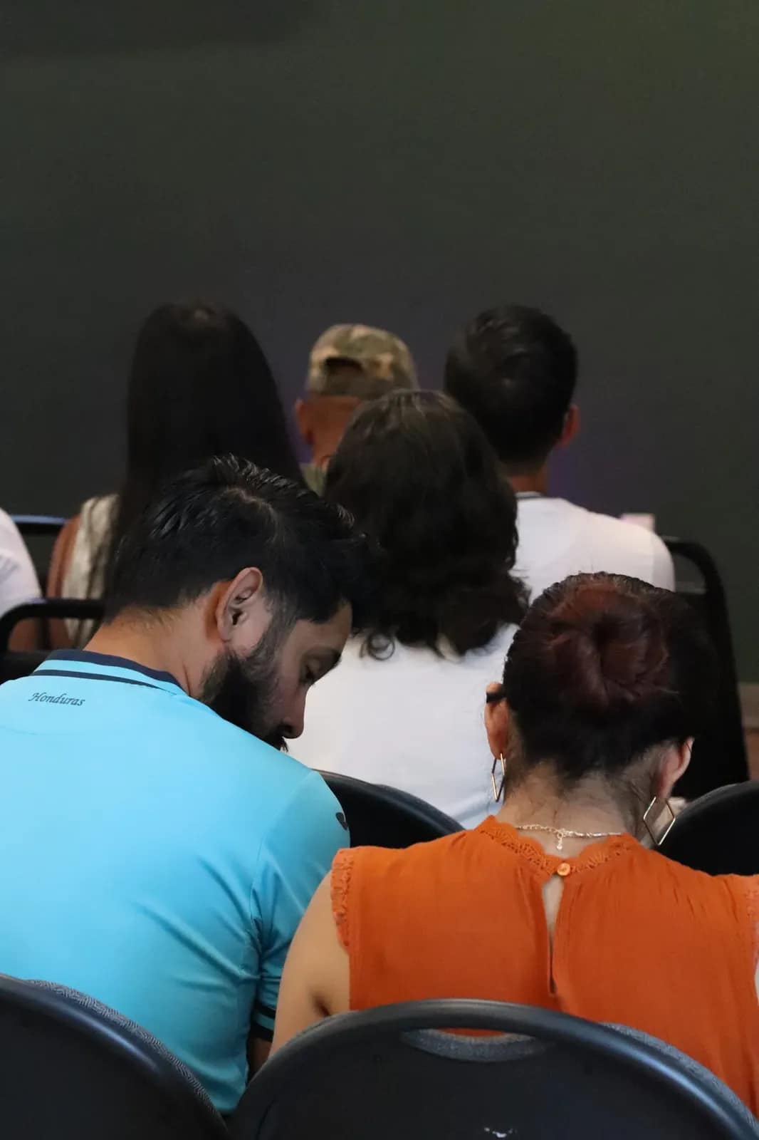 Varios se toman de las manos para orar inclinados en grupo