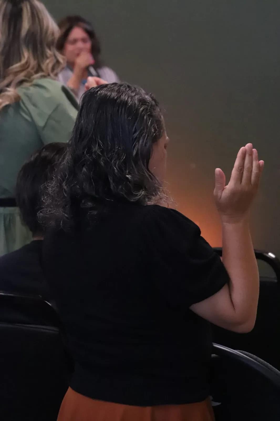 Dos mujeres oran juntas inclinadas al final del servicio