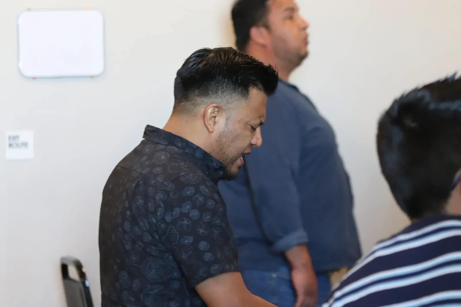 Los hombres adoran de pie con la cabeza inclinada