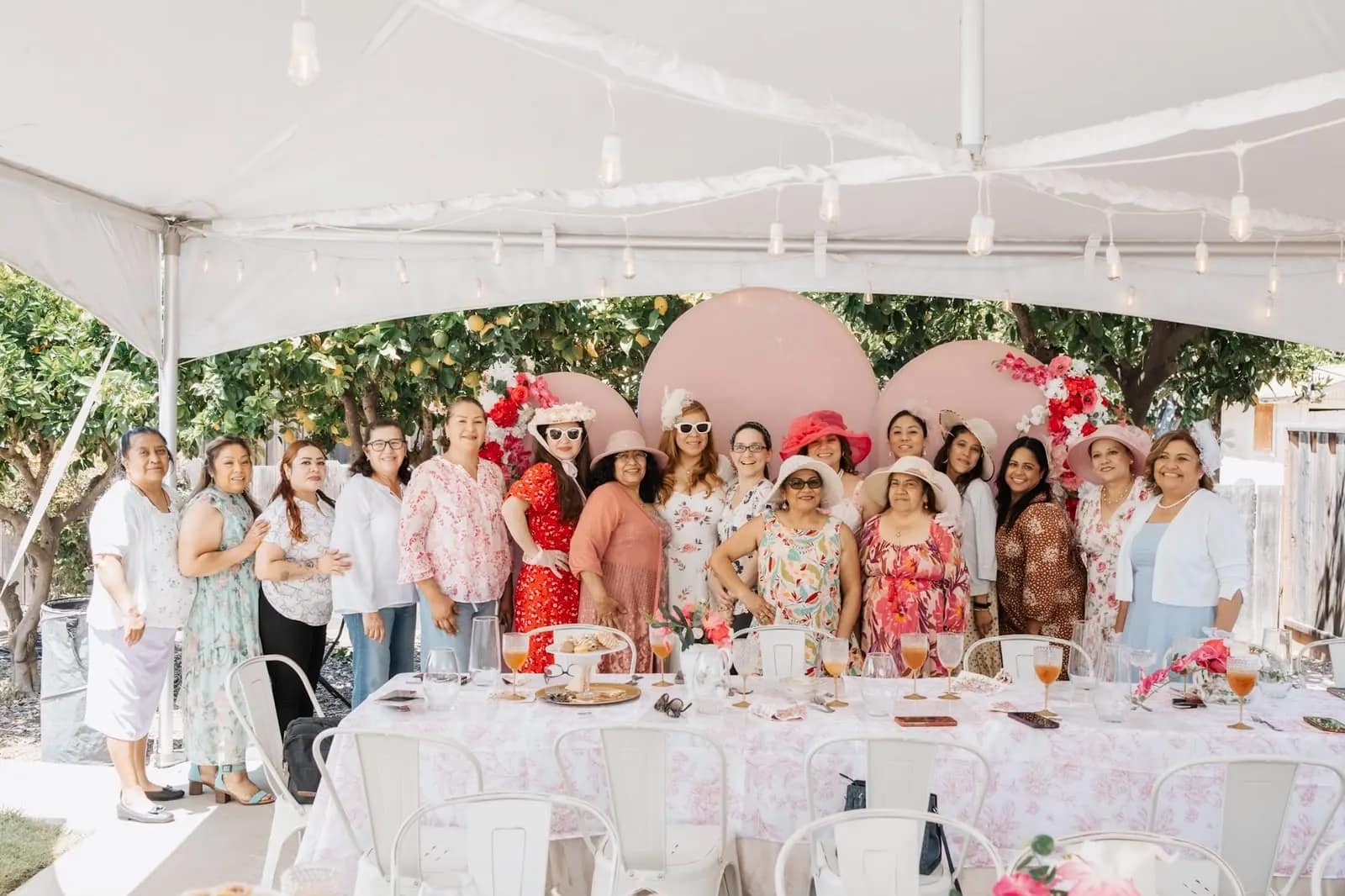 Las mujeres de la congregación posan juntas bajo la carpa al final de la celebración
